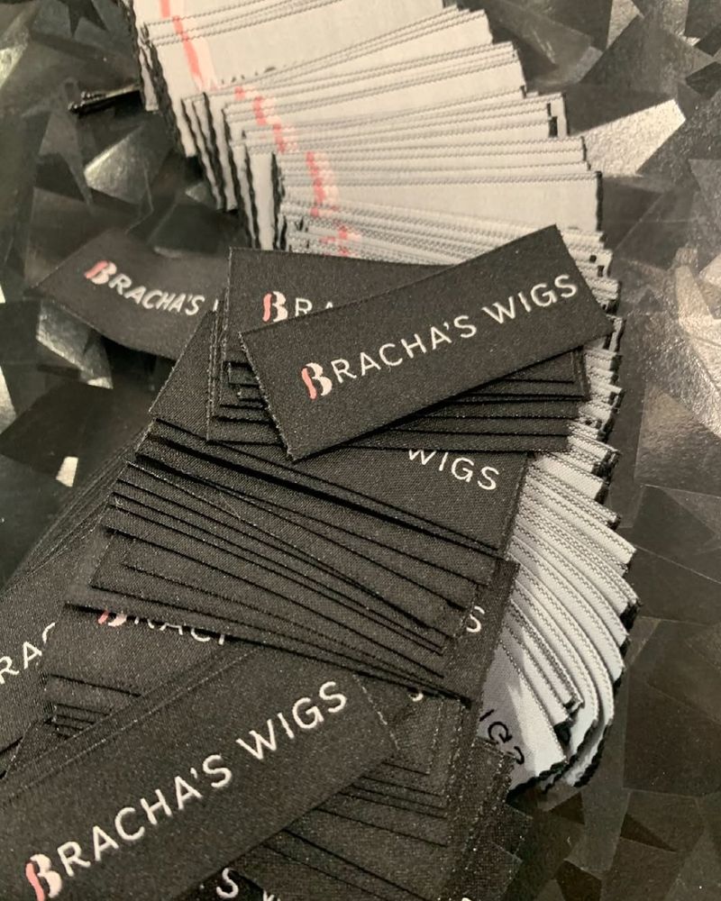 Bracha&rsquo;s Wigs labels, in pink and white